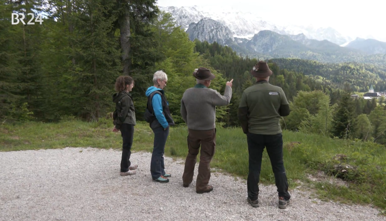 Vier Menschen vor Bergpanorama, am Stillen Wald in Mittenwald stehen sie und bewundern die Berge.